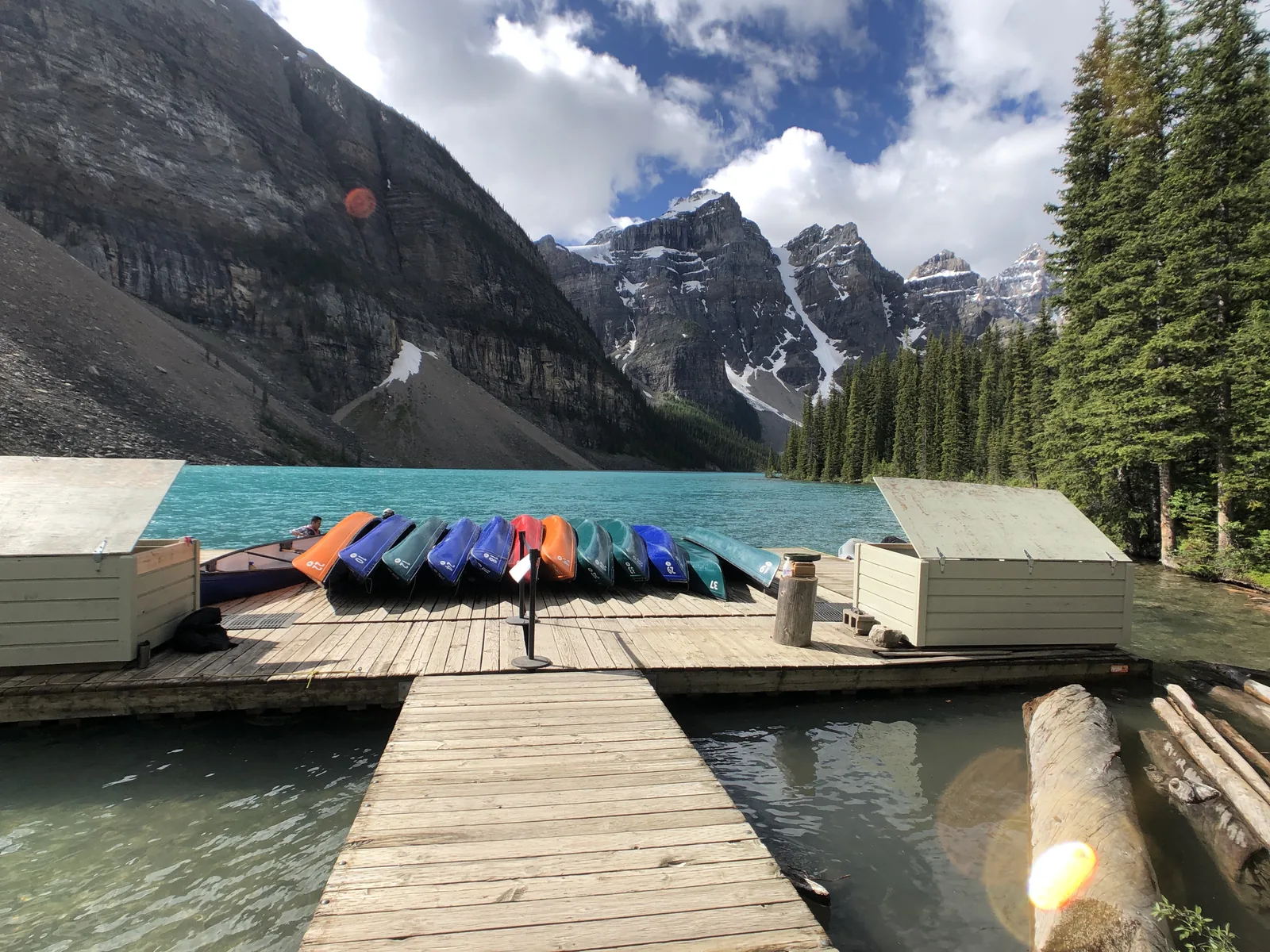 Colourful rental canoes on a wooden dock at Moraine Lake in Banff National Park.
