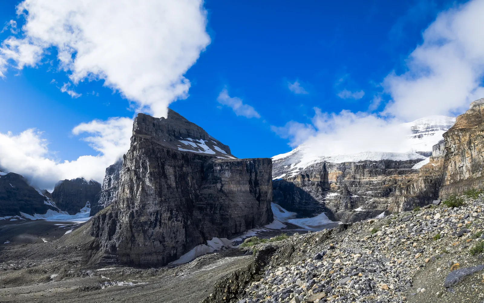 Scree and rocks in Banff National Park at the Plain of Six Glaciers, glaciers and clouds behind.