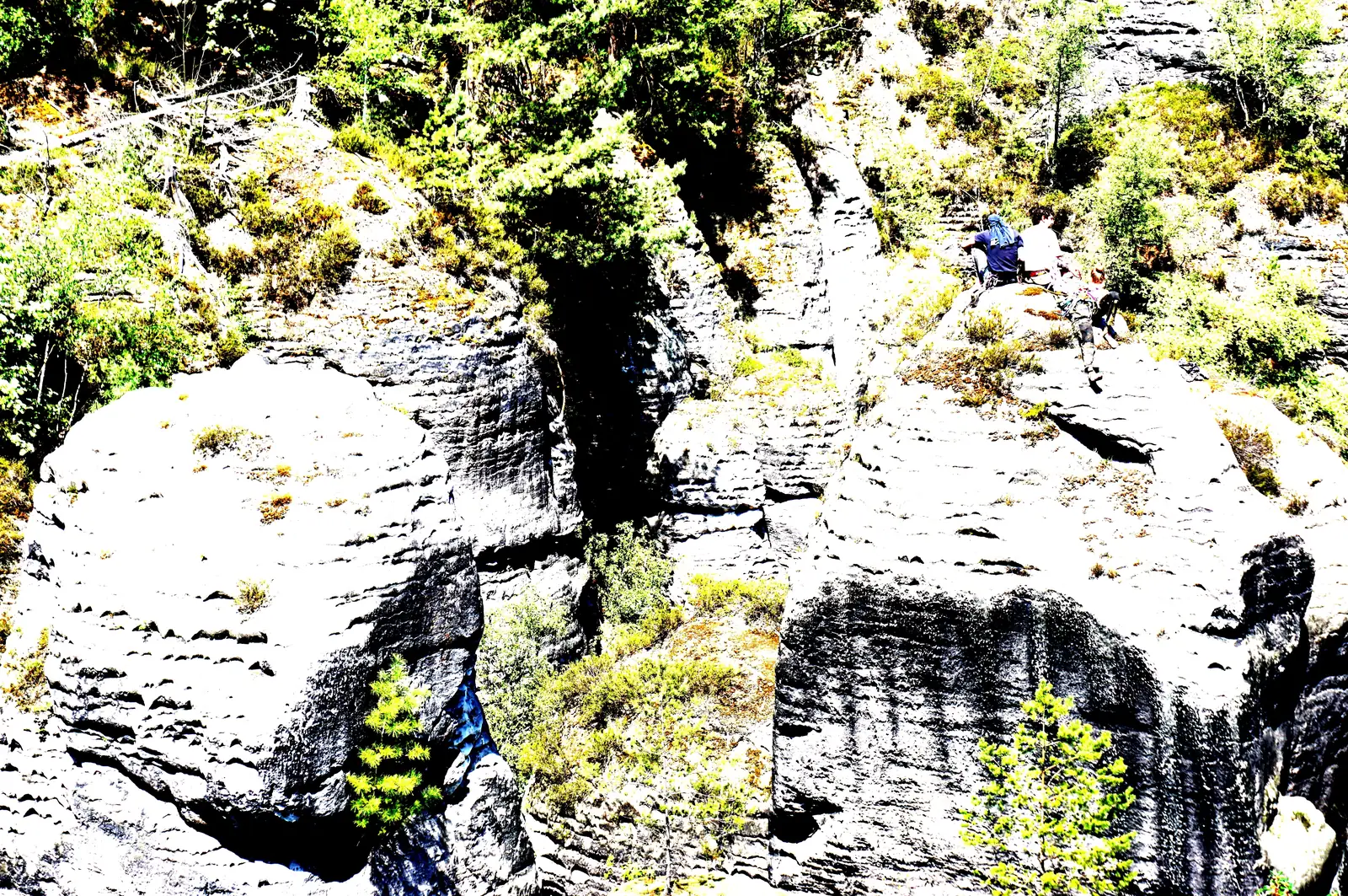 View from the Bastei Bridge in Saxon Switzerland National Park of climbers on the Basteischluchtturm and the Rudolf-Hofmann-Spitze