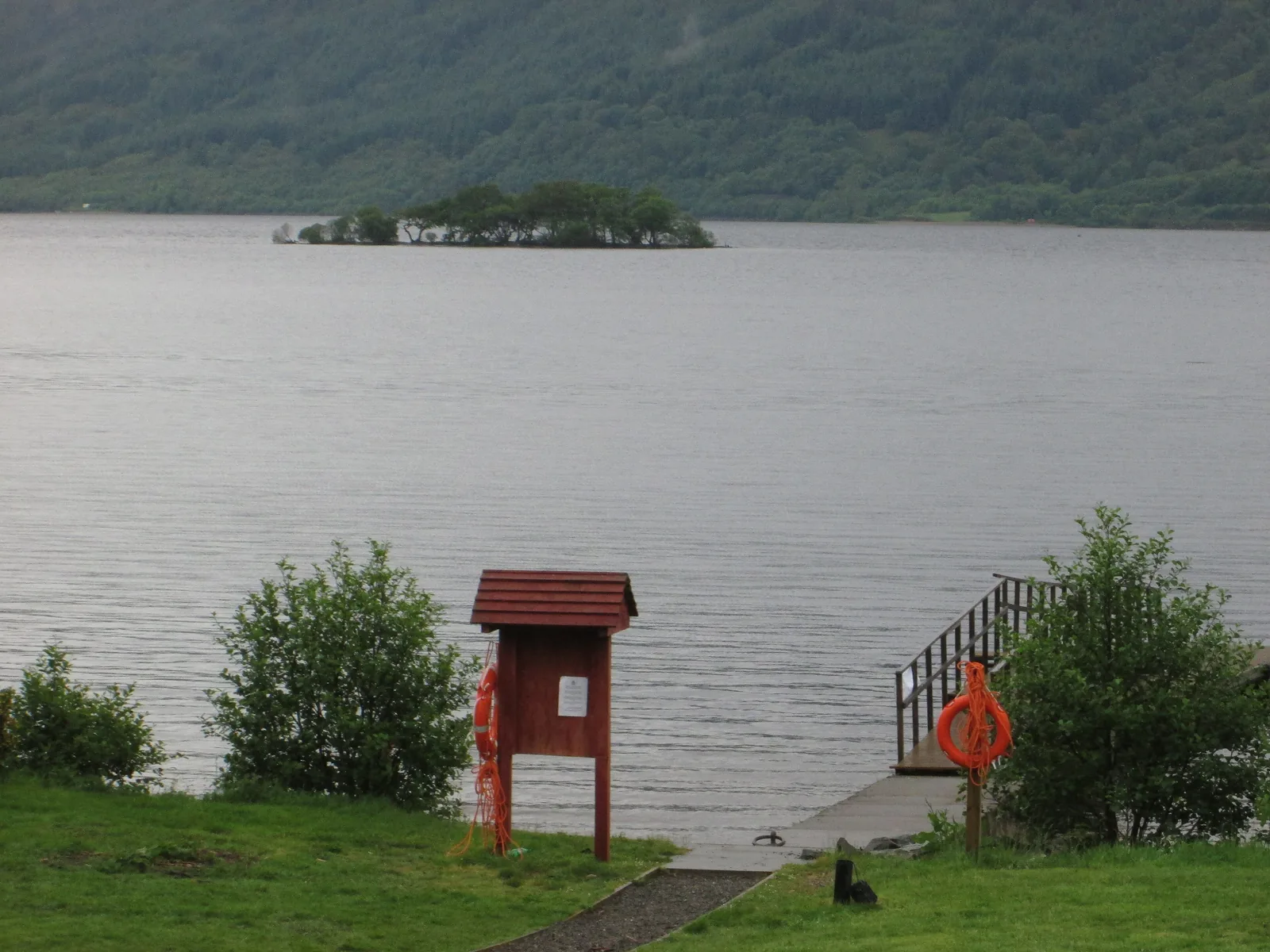 The small pier at Rowardennan on Loch Lomond with a red information board, starting point for Ben Lomond