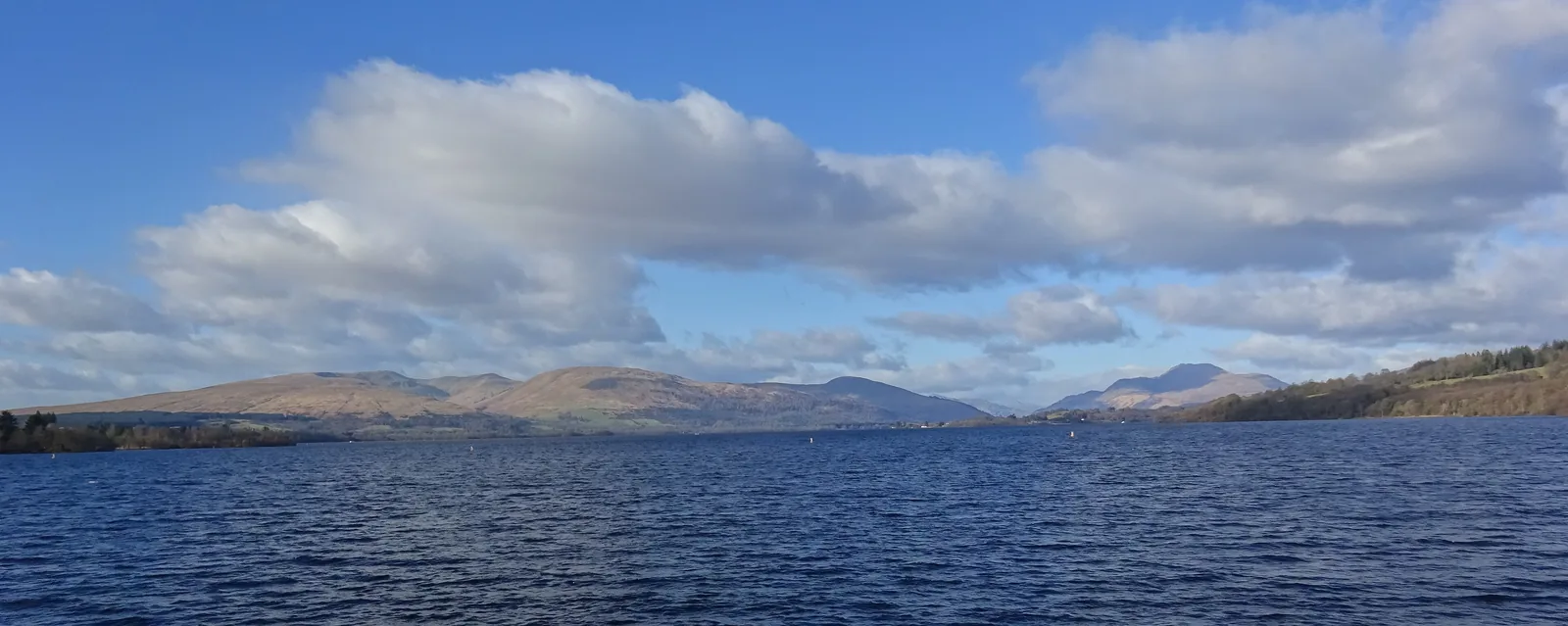Ben Lomond on the horizon above the wide Loch Lomond, seen from the pier at Balloch