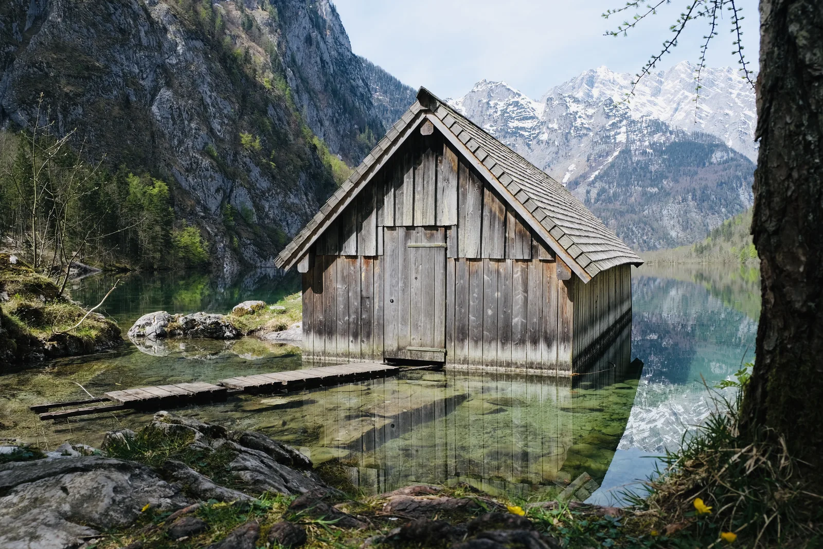 Wooden boathouse at the Fischunkelalm in the clear water of the Obersee