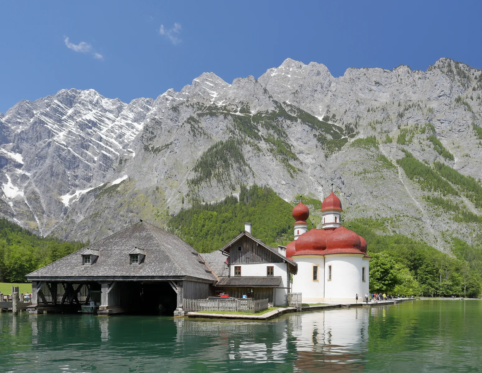 The pilgrimage church of St. Bartholomä in Berchtesgaden National Park, with red onion domes on the shore of Lake Königssee, the Watzmann East Face behind