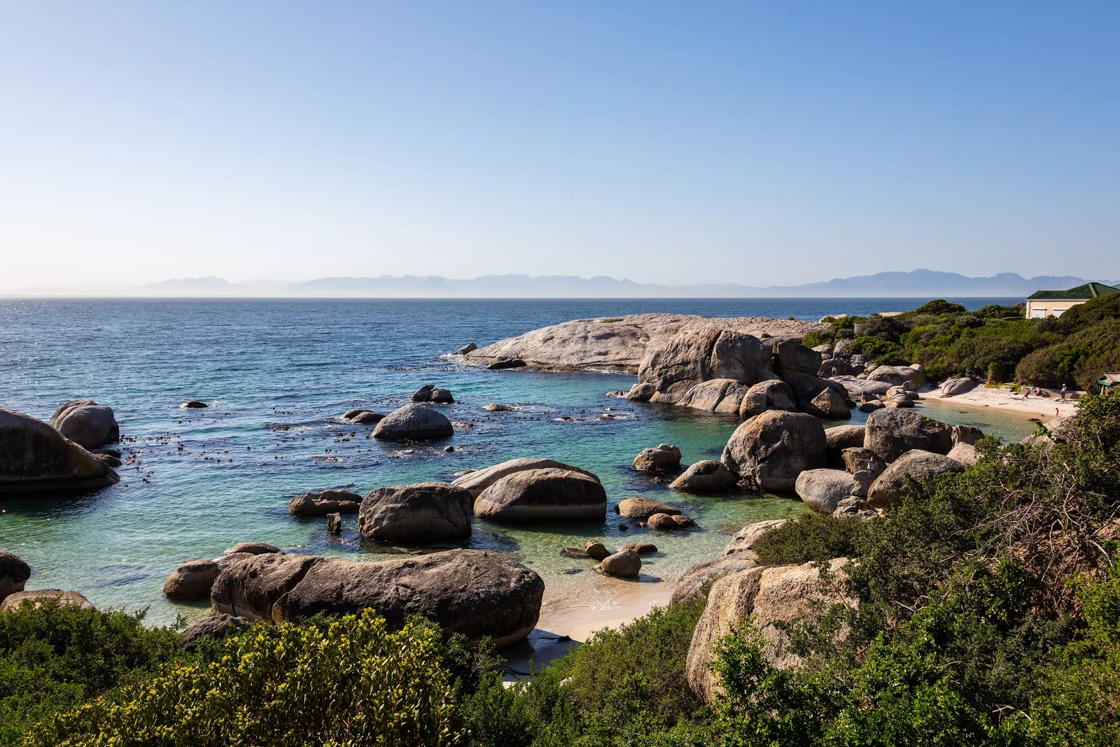 View over the rocky coves of Boulders Beach with large granite boulders in the turquoise water of False Bay