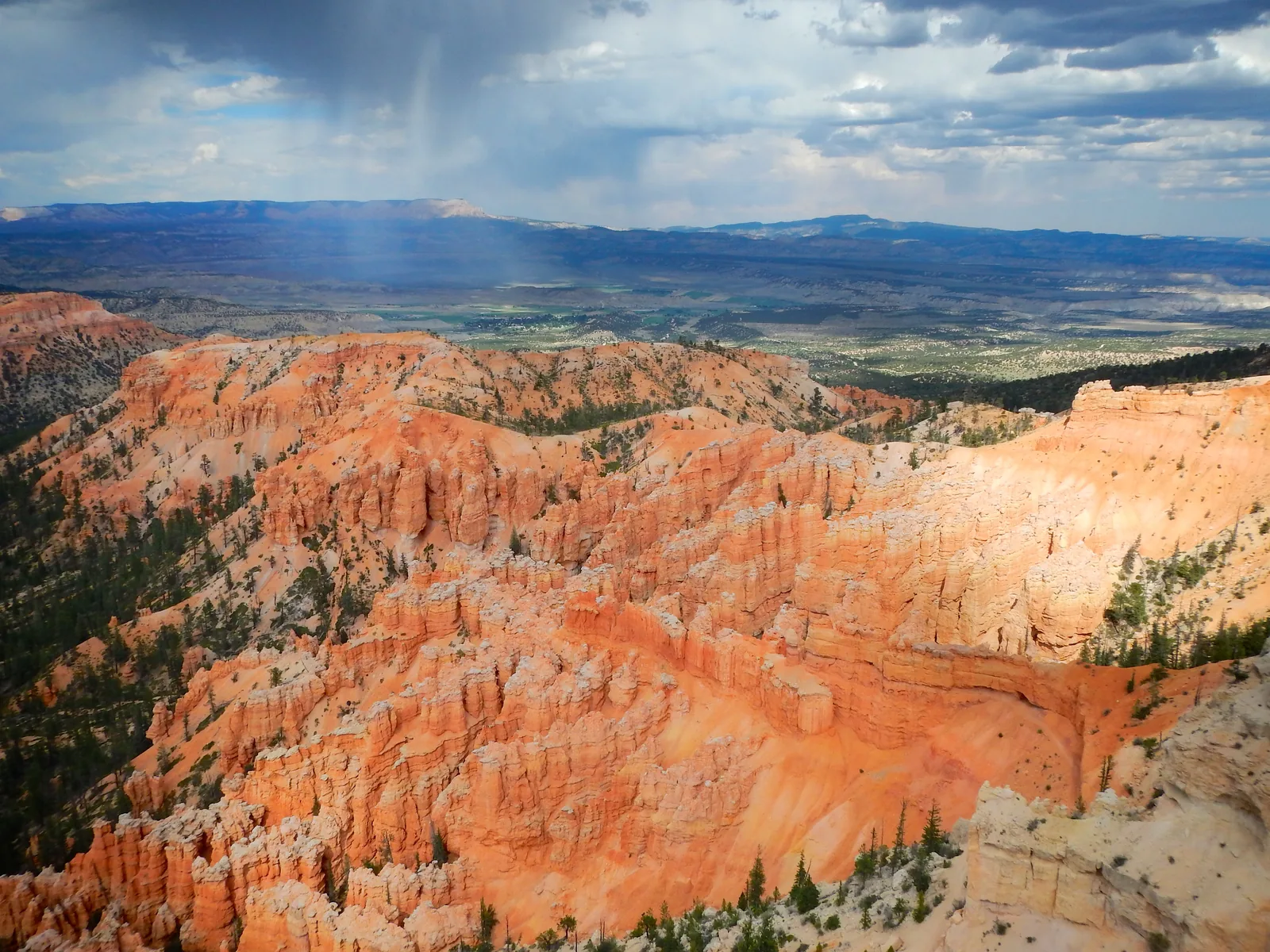 Wide view from Yovimpa Point in Bryce Canyon National Park over red rock steps and wooded plains to distant plateaus