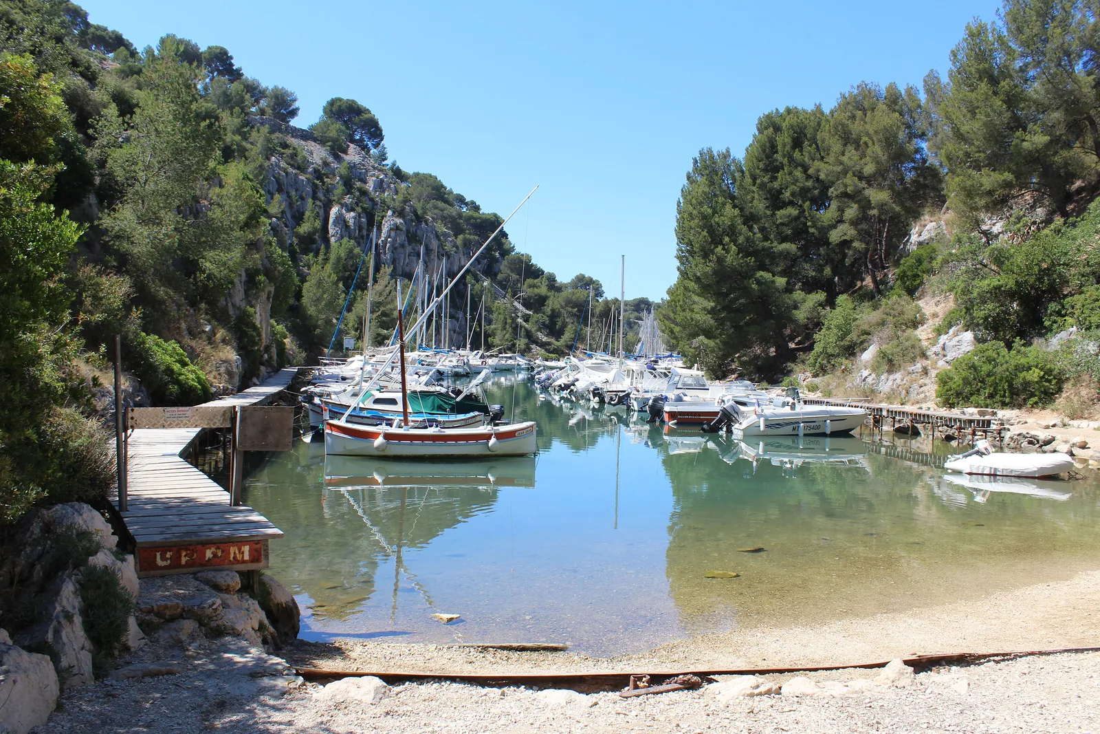 The Calanque de Port-Miou near Cassis in Calanques National Park: sailing boats at the jetty, clear water and pines on the rocks