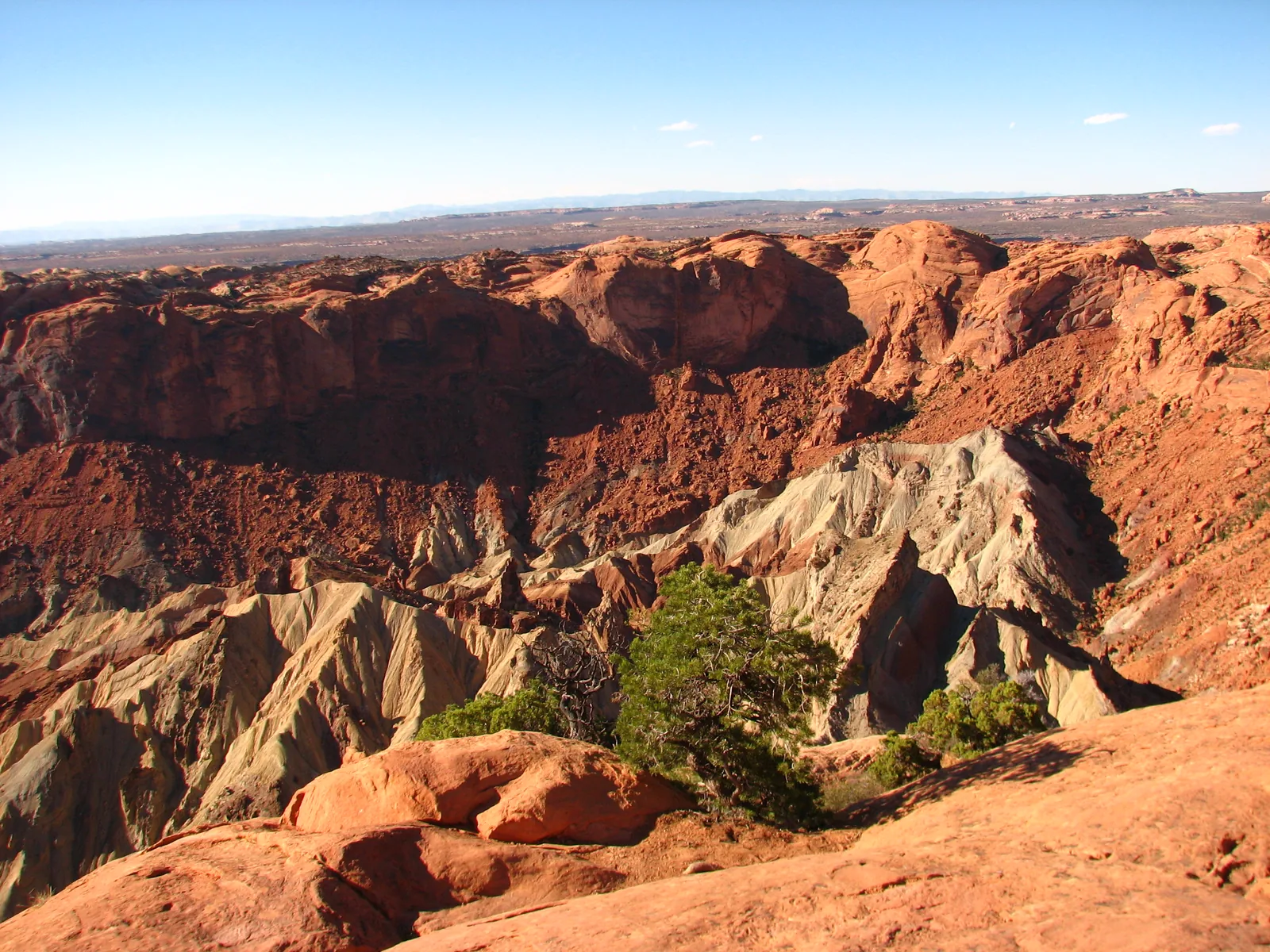 View from the rim into Upheaval Dome in Canyonlands National Park: pale, steeply tilted rock layers surrounded by red rock