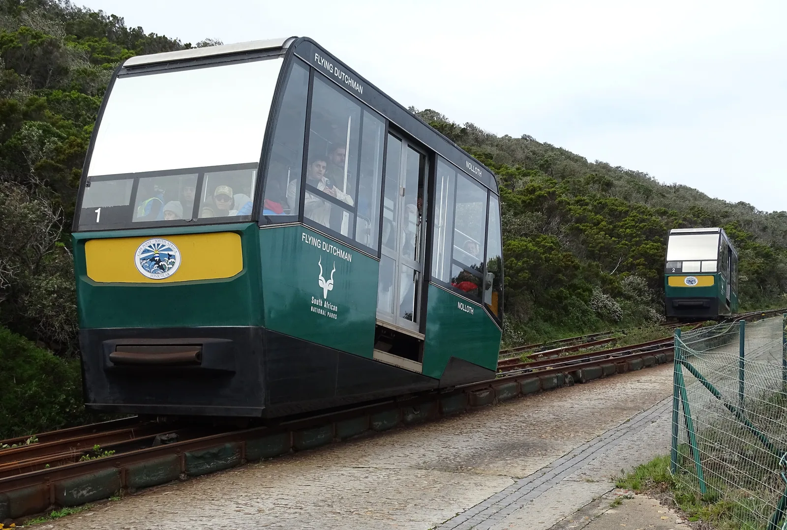 A green car of the Flying Dutchman funicular climbs the slope at the Cape of Good Hope, a second car behind it