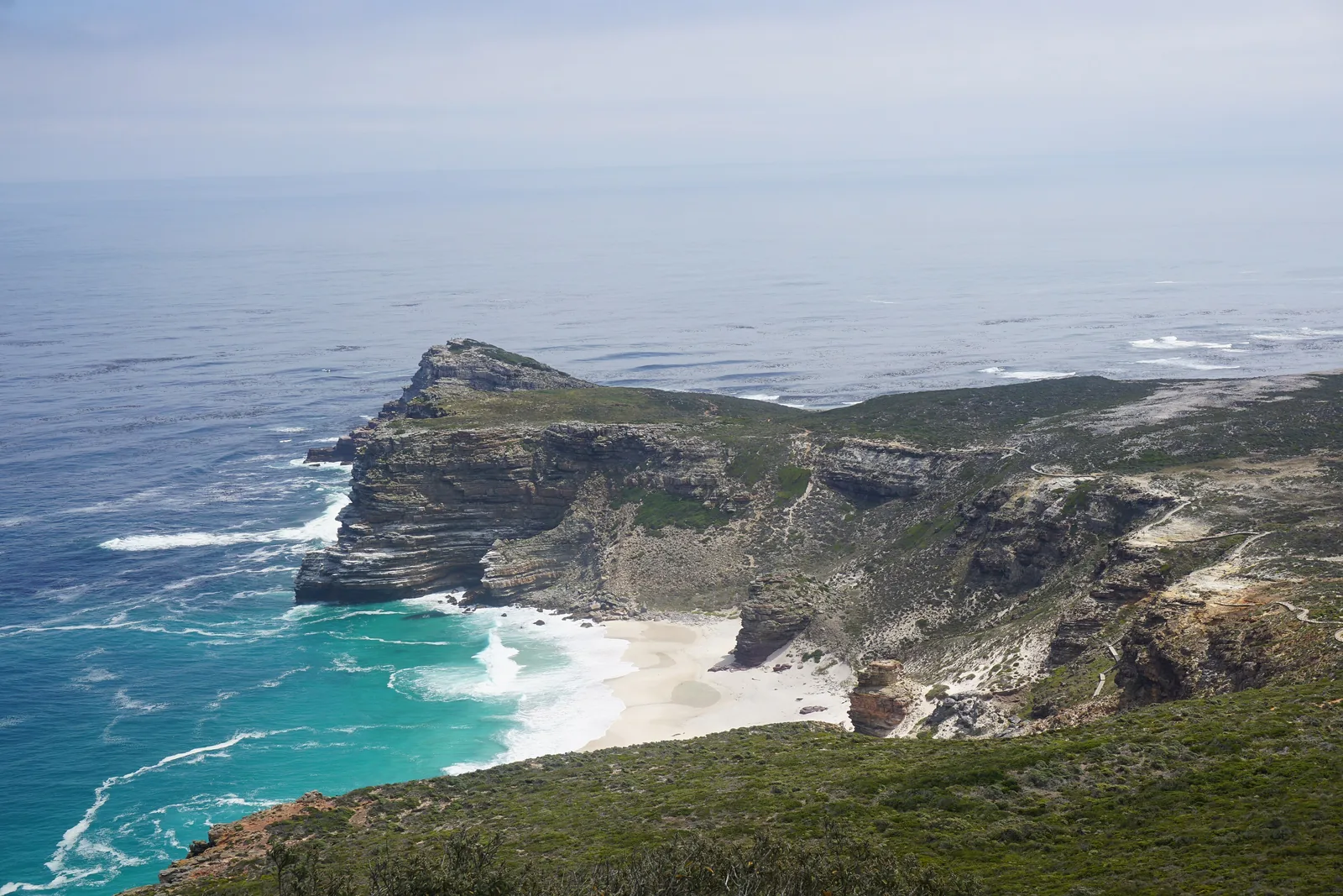 View from Cape Point down to the Cape of Good Hope with a pale sandy beach and surf