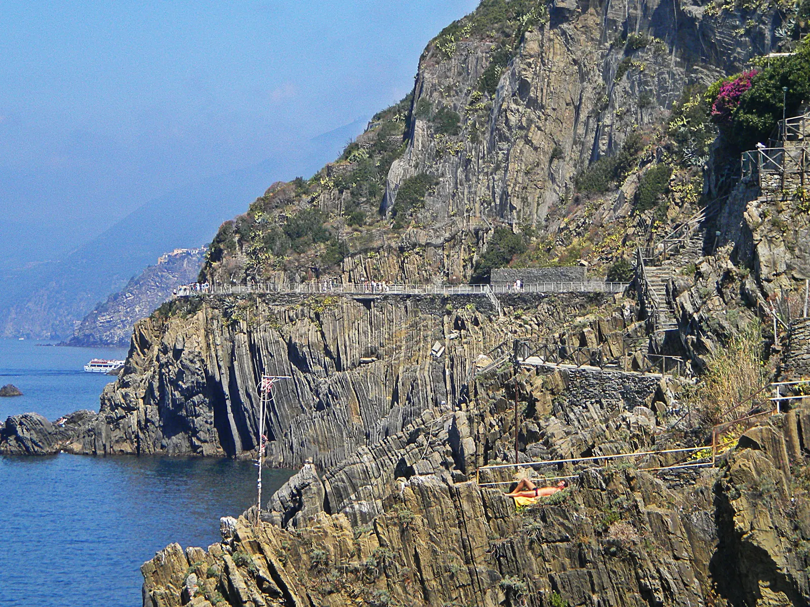 The Via dell'Amore in Cinque Terre National Park: a walled path with a railing on the steep, layered rock coast above the sea