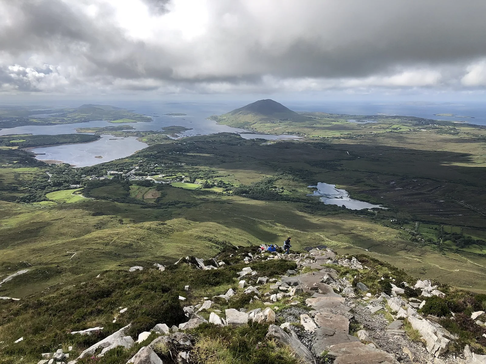 Hikers on the path up Diamond Hill in Connemara National Park, with heath and bog all around