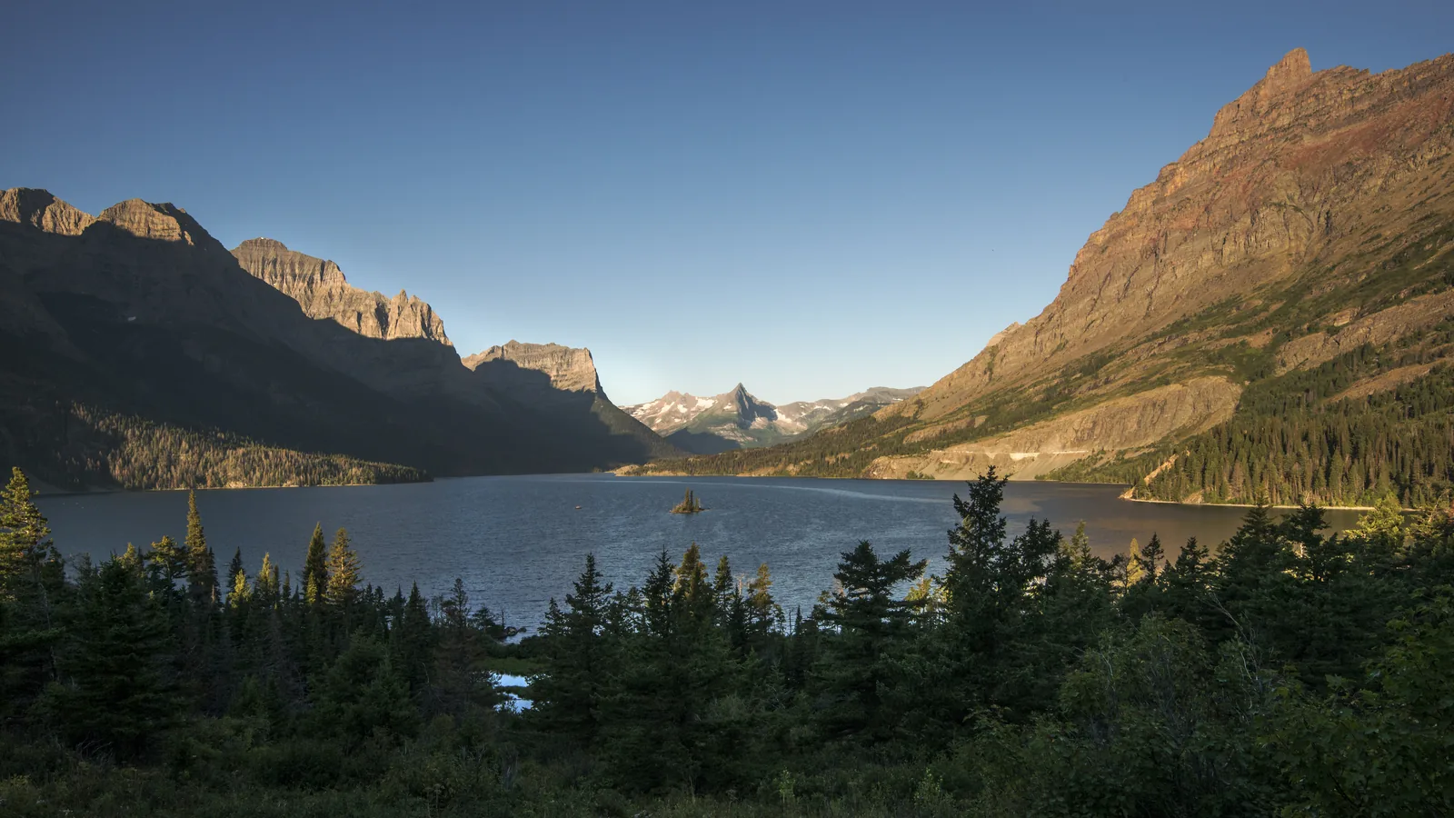 St. Mary Lake in Glacier National Park, Montana, with the small wooded Wild Goose Island, framed by steep mountainsides in evening light