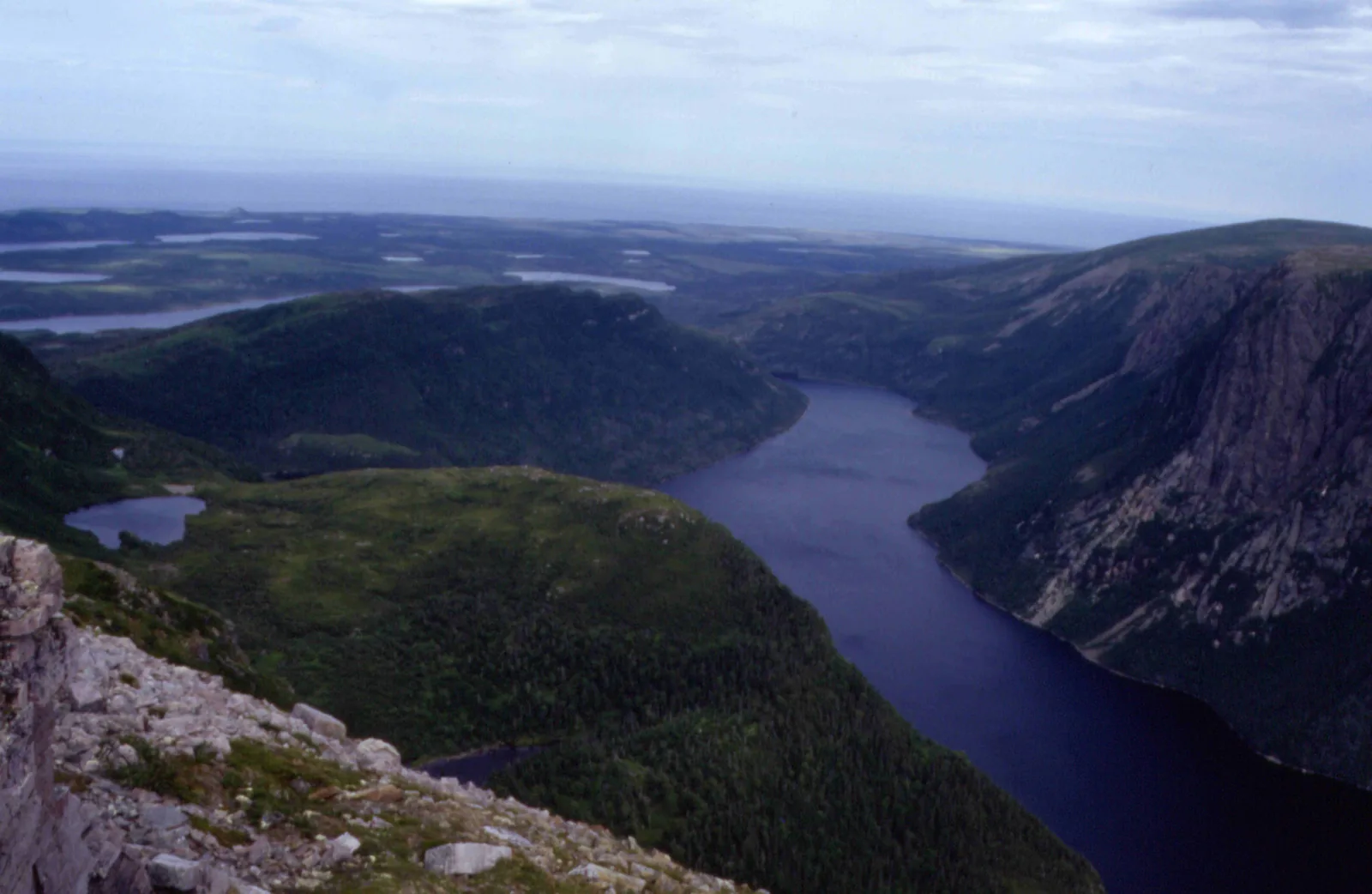 View from the summit plateau of Gros Morne in Gros Morne National Park down to narrow, dark Ten Mile Pond between steep, forested valley sides