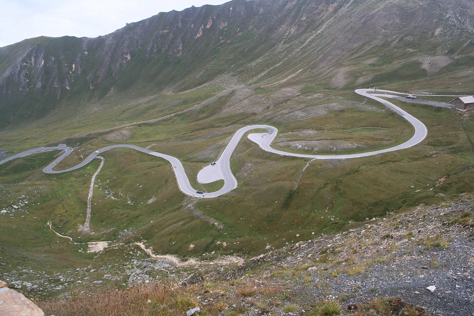 Hairpin bends of the Grossglockner High Alpine Road wind across green high-mountain slopes beside Hohe Tauern National Park
