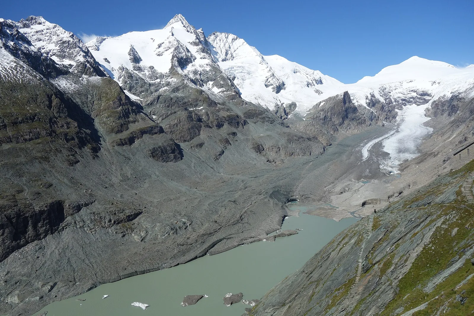 The snow-covered Grossglockner above the Pasterze glacier and its lake in Hohe Tauern National Park, seen from the Kaiser-Franz-Josefs-Höhe on the edge of the park