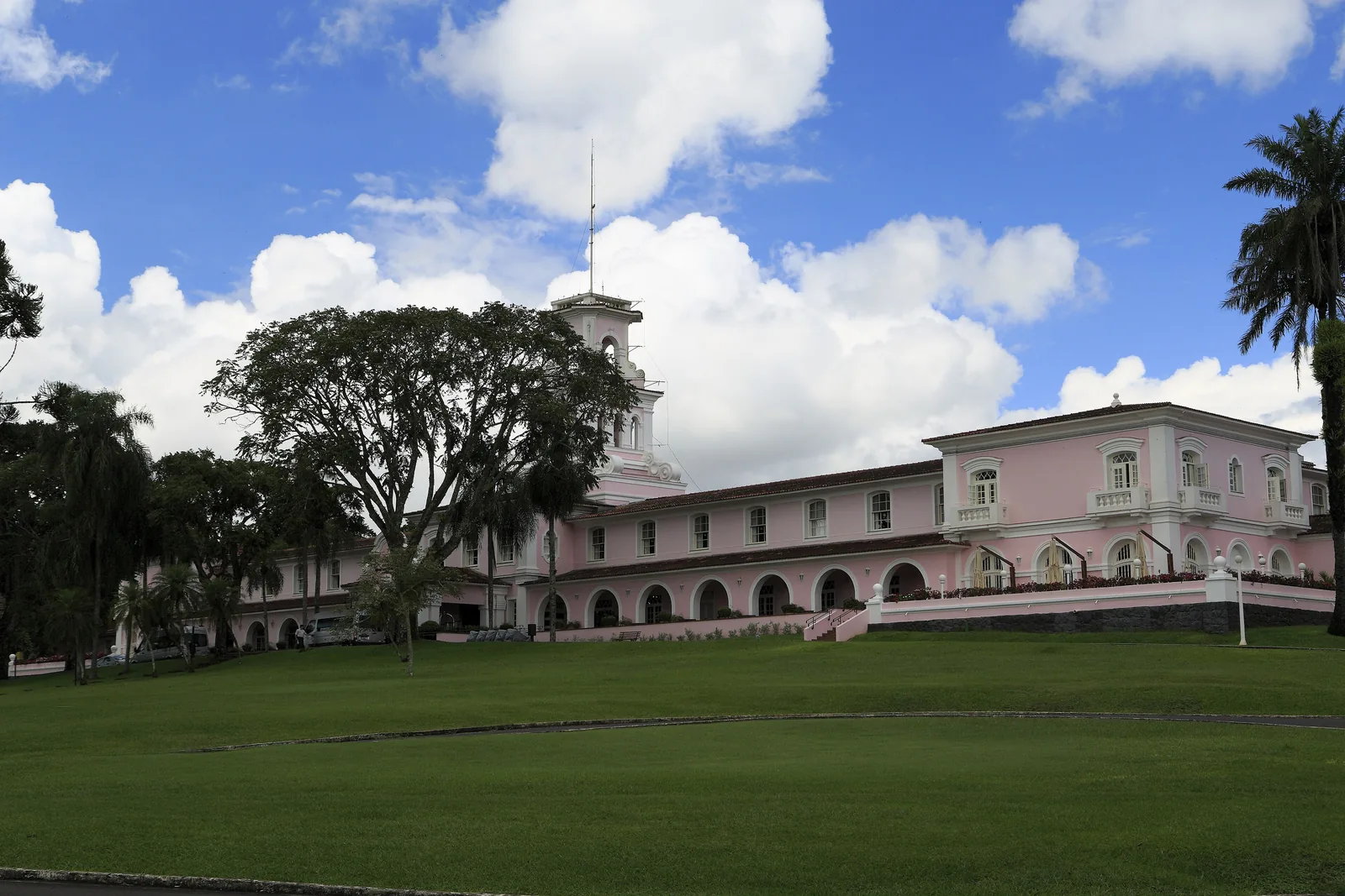 The pink Belmond Hotel das Cataratas with its tower stands behind a wide lawn in Iguaçu National Park