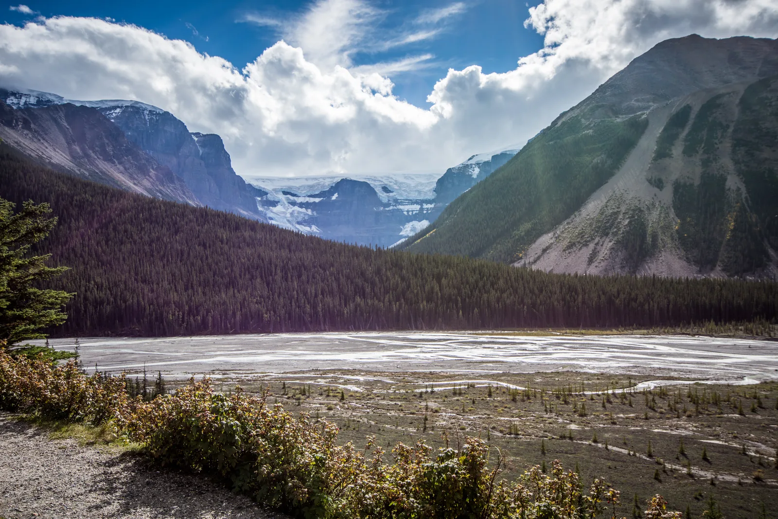 Wide gravel valley on the Icefields Parkway, an icefield between the ridges behind
