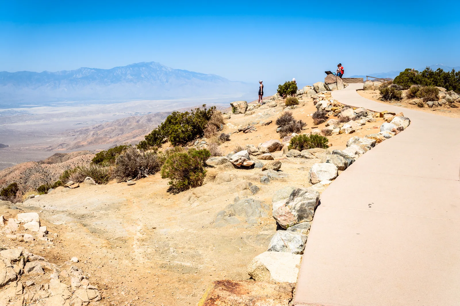 Paved viewpoint path at Keys View in Joshua Tree National Park looking across the hazy Coachella Valley to Mount San Jacinto