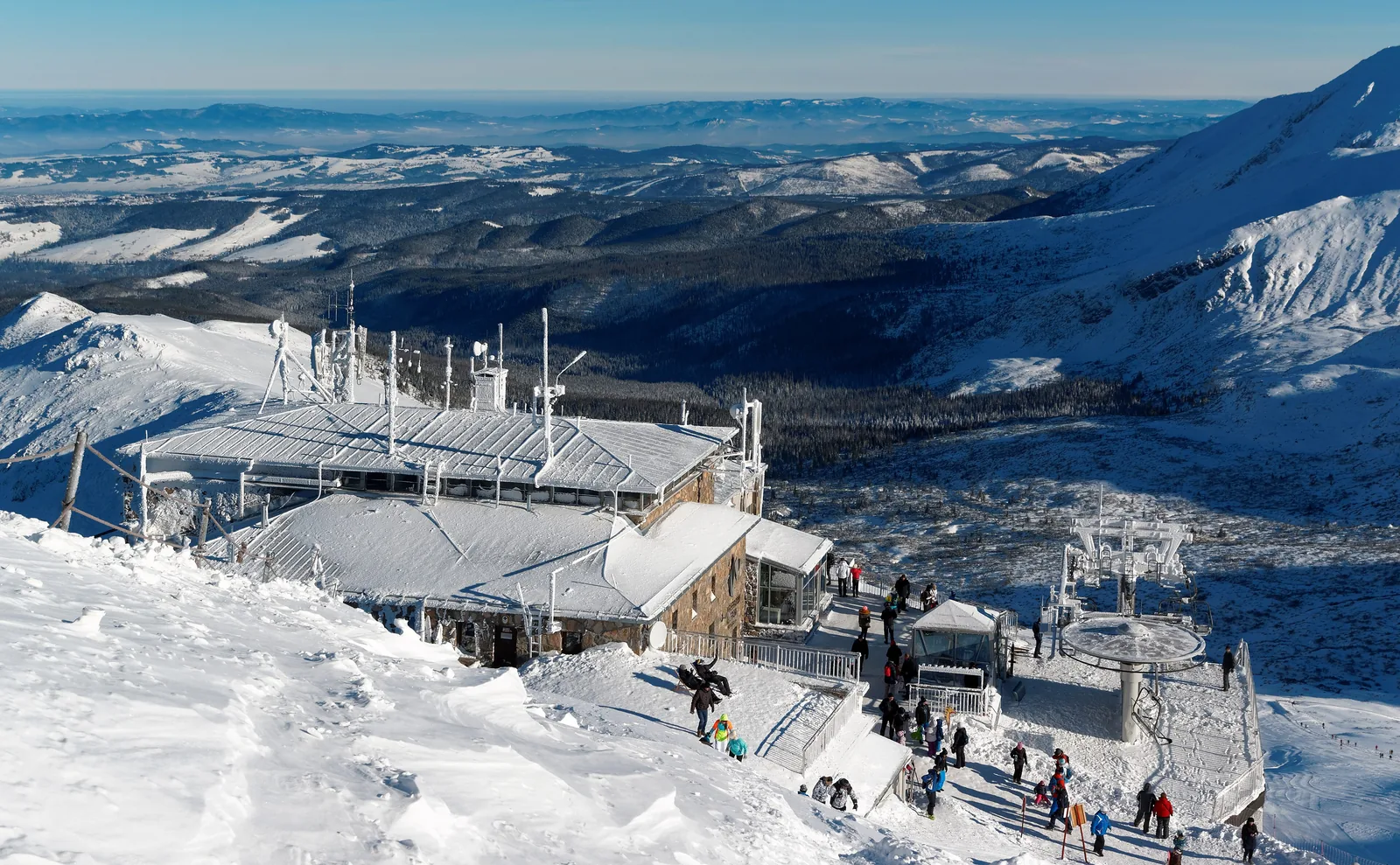 The Kasprowy Wierch cable car top station in winter, snow-covered slopes and visitors, a wide view to the north