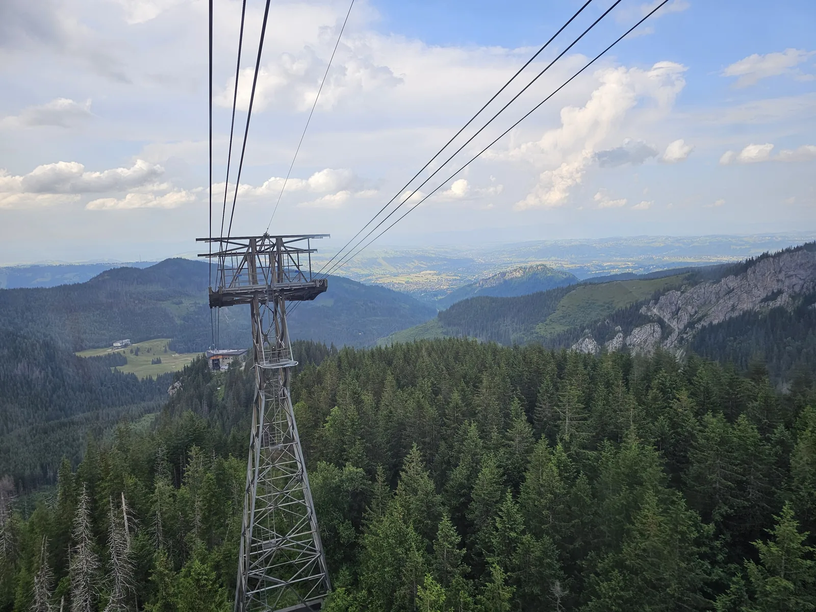 View from the cable car towards Kasprowy Wierch onto a tower and the wooded valley below