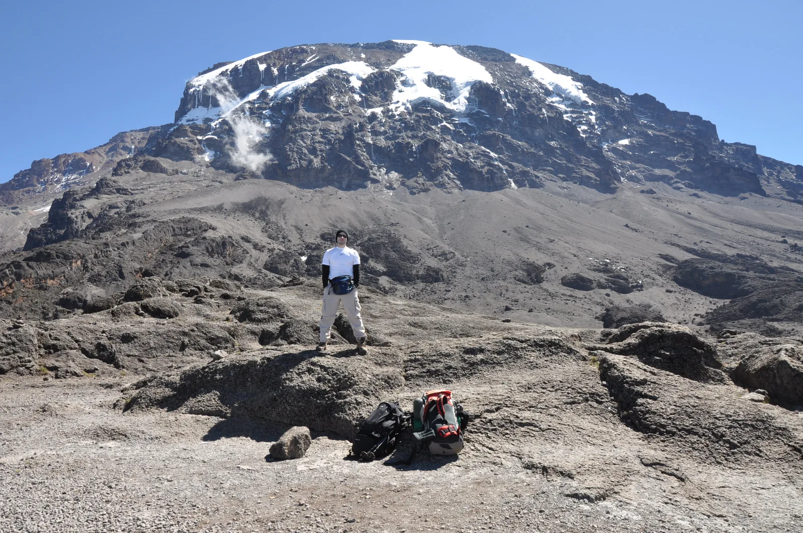 View from the Barranco Wall in Kilimanjaro National Park of the glaciated south face of Kibo, a climber on the scree