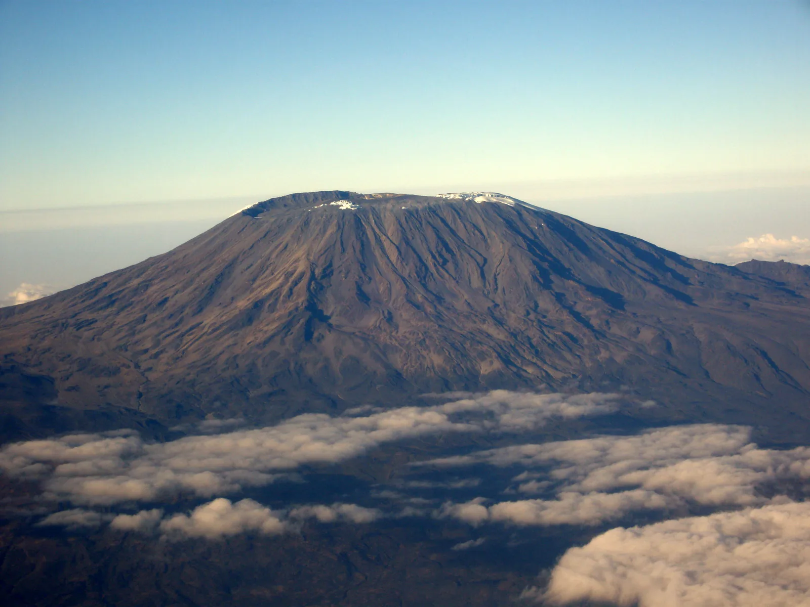 Kibo, the main summit of Kilimanjaro, seen from the northeast above a sea of clouds, with remnants of ice on the crater rim