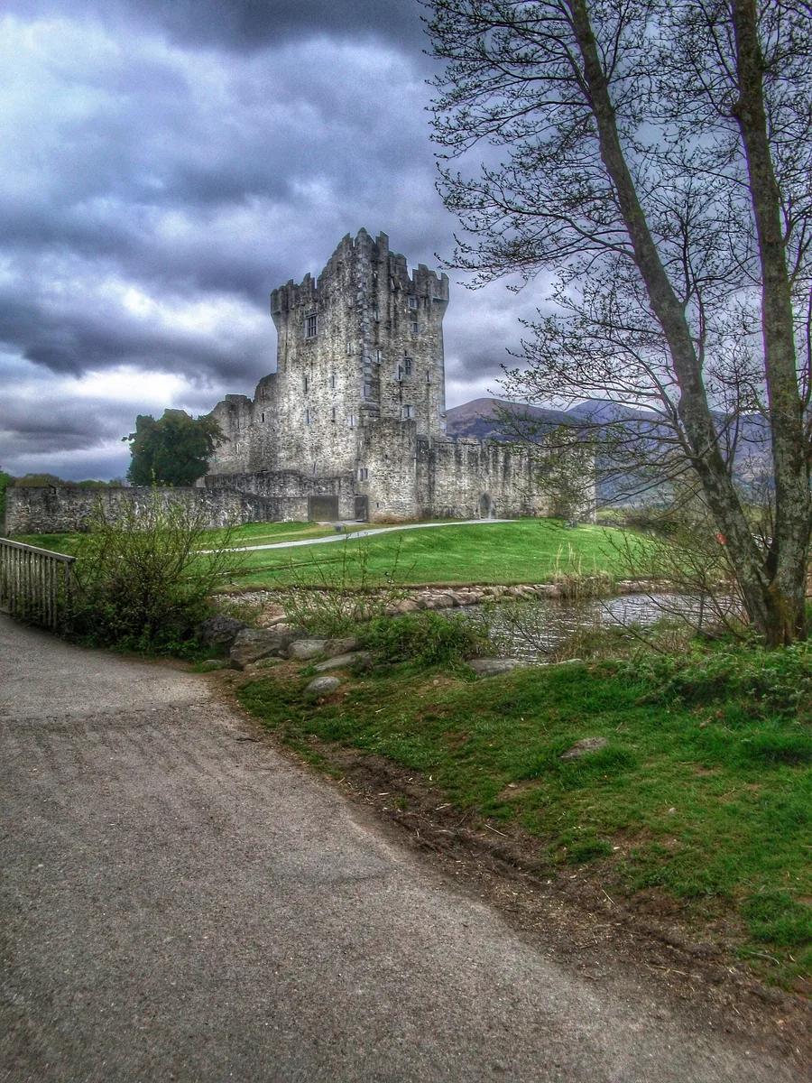 Ross Castle in Killarney National Park, a stone tower house behind a path, in winter