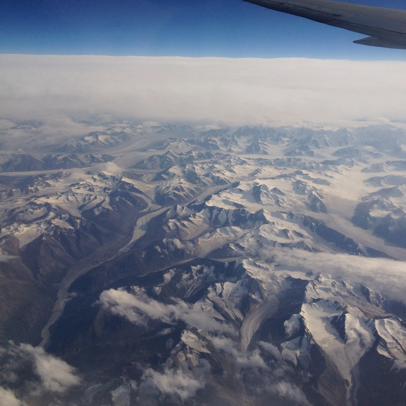 View from an aircraft over endless snow-covered ranges and glaciers in Kluane National Park, the wing at the top of the picture