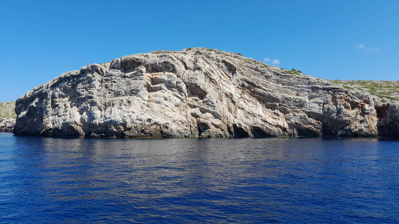 Sheer cliff of an island in Kornati National Park, seen from the water.