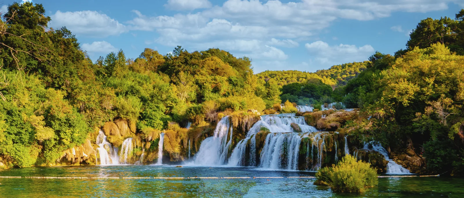 Broad Krka cascades in Krka National Park over overgrown tufa steps in the evening light