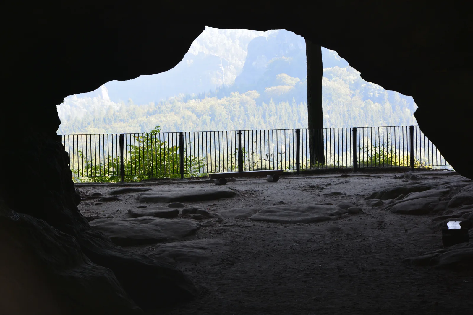 View out of the dark Kuhstall rock arch to the rocks of the rear part of Saxon Switzerland