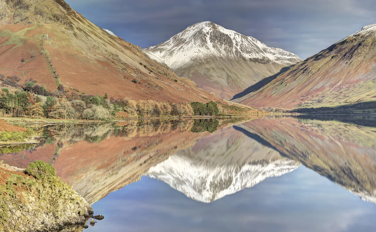 Wast Water in the Lake District National Park reflecting the fells at Wasdale Head, with the snow-covered summit of Great Gable in the centre