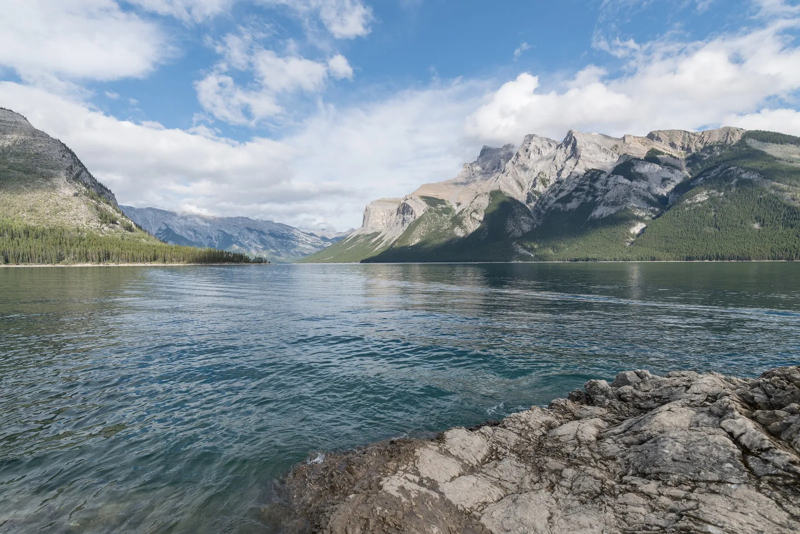 Lake Minnewanka in Banff National Park from the rocky west shore, Mount Inglismaldie on the right, the lake stretching far up the valley.
