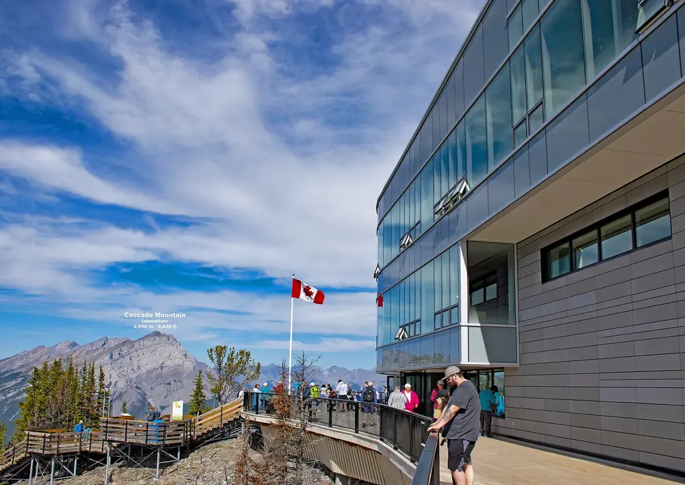 Modern upper station of the Banff Gondola in Banff National Park on Sulphur Mountain with wooden boardwalks and views of the surrounding peaks.
