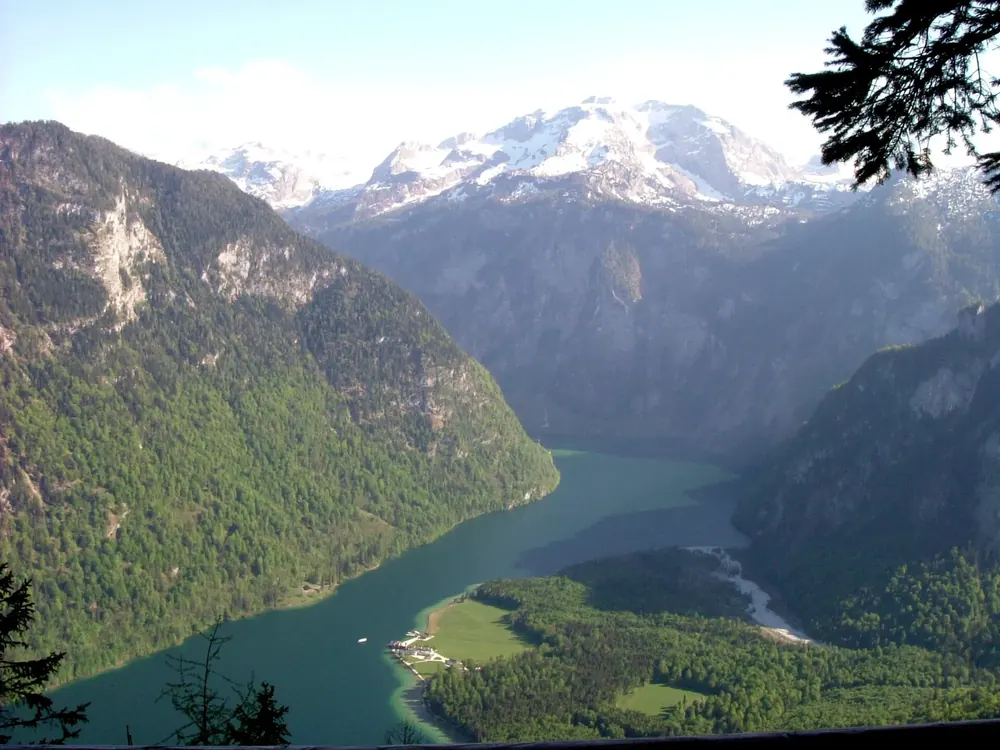 View from the Kührointalm in Berchtesgaden National Park down to Lake Königssee between steep mountainsides, glaciated peaks behind