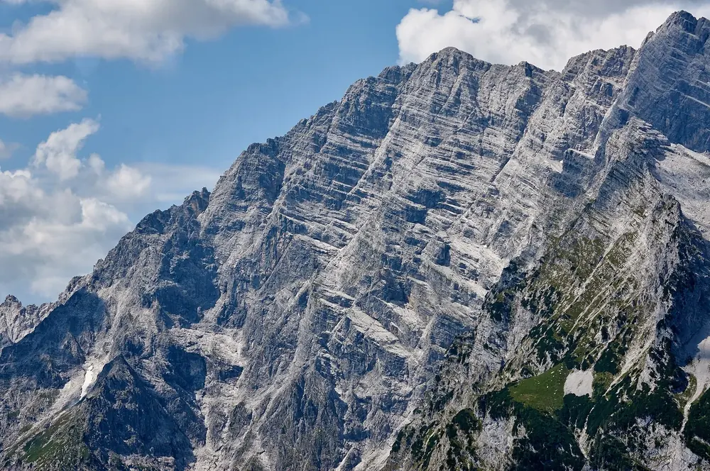 Watzmann East Face with the Südspitze in Berchtesgaden National Park: a huge banded limestone wall below cumulus clouds