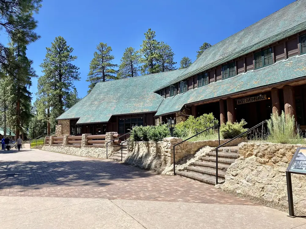 The Lodge at Bryce Canyon in Bryce Canyon National Park: a rustic stone and timber building with a green shingle roof, steps and pines in front