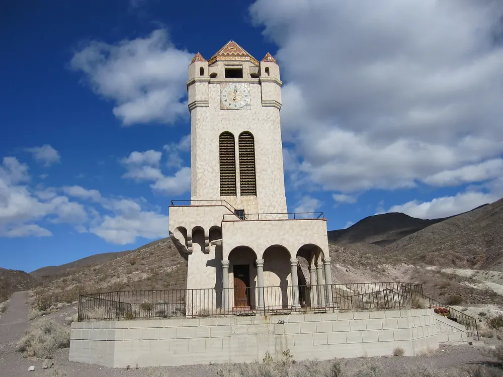 Scotty's Castle in Death Valley National Park: pale tower with a clock and arcades, barren desert hills behind under a blue sky