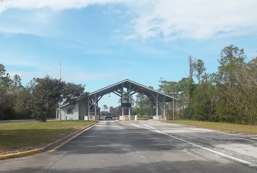 Main entrance of Everglades National Park near Homestead: entrance booths under a large gabled roof over the access road