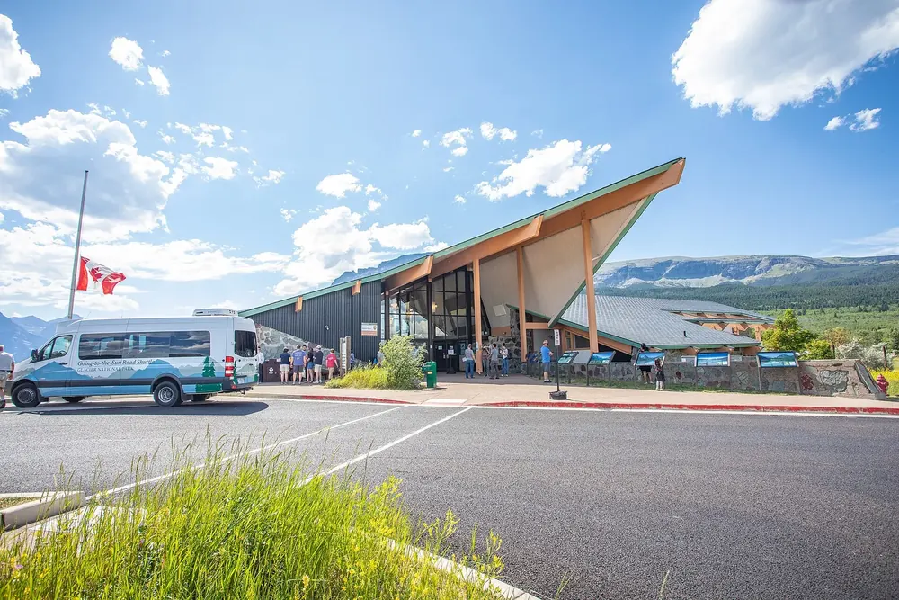 St. Mary Visitor Center: a low building with a steeply pointed roof, with a forecourt and a shuttle bus in front