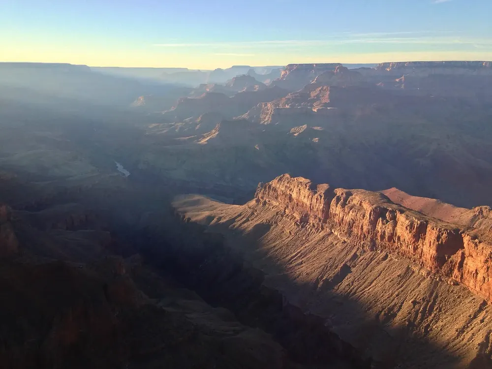 Lipan Point in Grand Canyon National Park at dusk: reddish lit rock walls above the deep, shadowed canyon