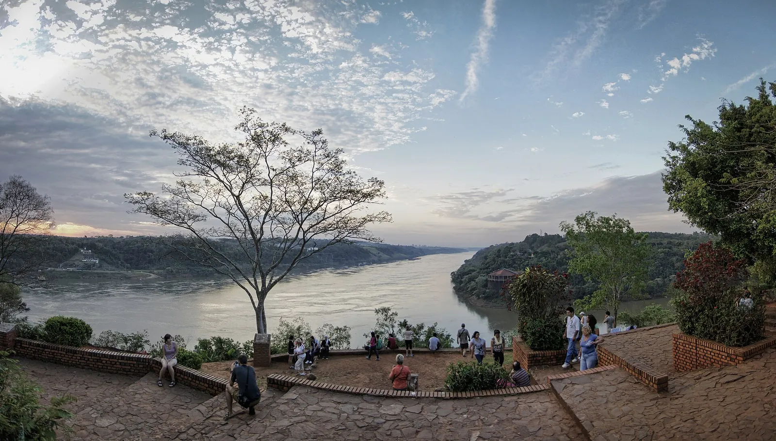 Viewing terrace at Hito Tres Fronteras in Puerto Iguazú overlooking the confluence of the Iguazú and Paraná rivers, a lone tree against a cloudy sky