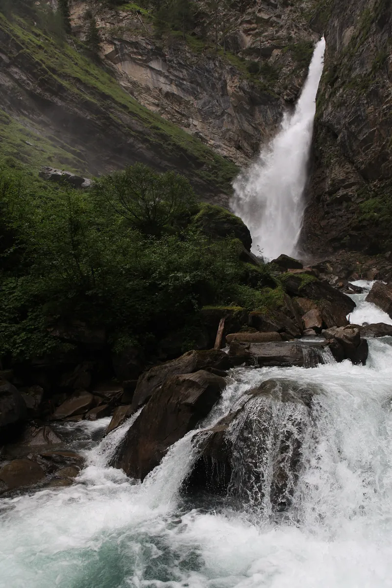The Gössnitz Falls in Hohe Tauern National Park: a high waterfall plunges over a rock face, foaming cascades between boulders below