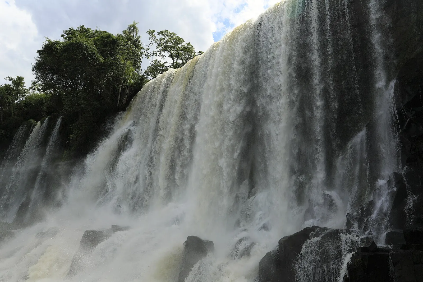 Salto Bossetti in Iguazú National Park seen close up from the lower circuit: a broad curtain of water over dark basalt, rainforest above