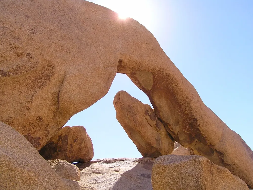 Arch Rock in Joshua Tree National Park: a natural arch of rounded, weathered granite with blue sky showing through