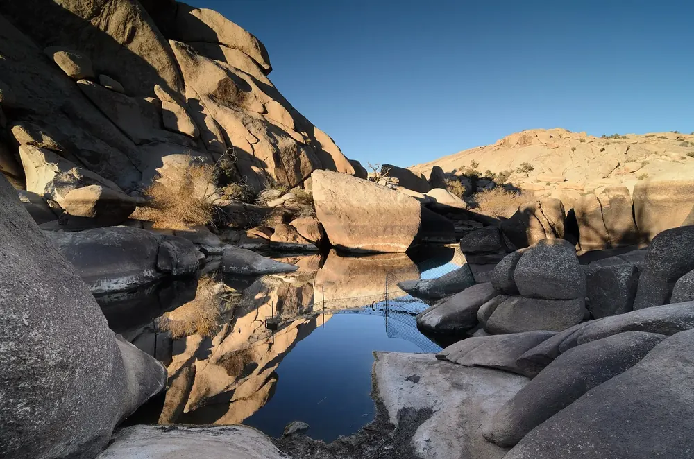 Barker Dam: a dammed pool between rounded granite rocks, reflecting the rocks in the evening light
