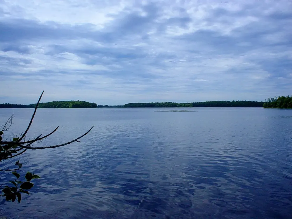 View from Jim Charles Point over the wide, calm Kejimkujik Lake with forested islands under clouds