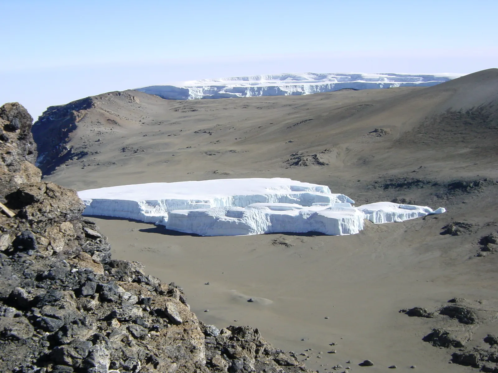 Furtwängler Glacier as a flat block of ice with vertical walls in the Kibo crater of Kilimanjaro National Park, the Northern Icefield beyond