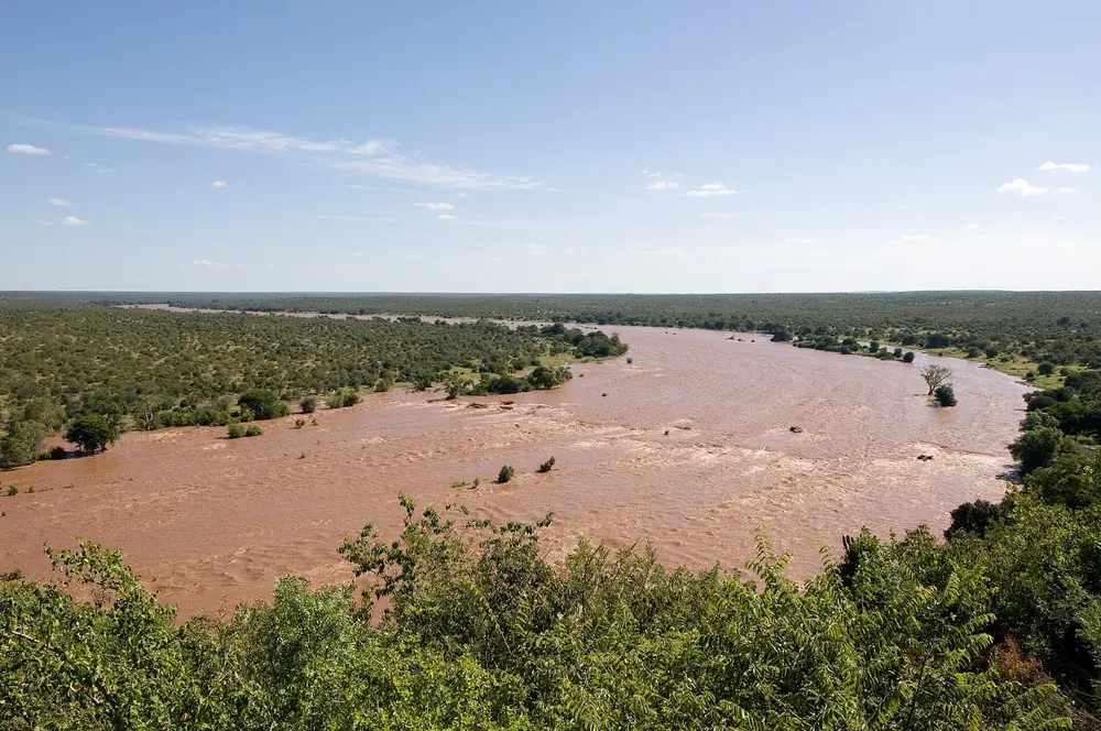 View from Olifants rest camp in Kruger National Park over the wide, reddish-brown Olifants River between green bushveld