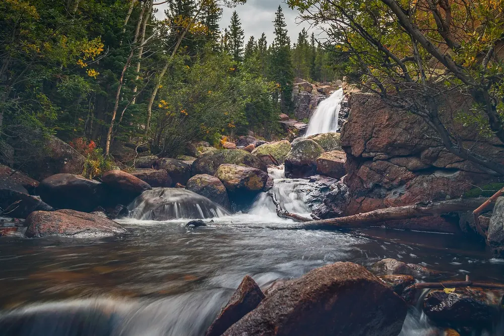 Alberta Falls in Rocky Mountain National Park: Glacier Creek tumbles over granite steps, surrounded by conifers and autumn foliage